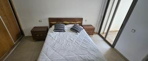 a bedroom with a bed with pillows on it at Résidences Mansbay Jasmin in Mansouria +10 photos