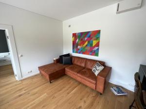 a living room with a couch and a painting on the wall at Airpark-Lodge in Lärz