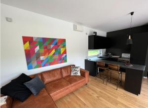 a living room with a couch and a colorful painting on the wall at Airpark-Lodge in Lärz