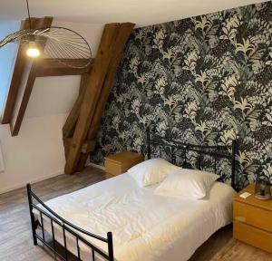 Schlafzimmer mit einem Bett mit einer schwarz-weißen Tapete in der Unterkunft Chambre d hôtes prêt du parc du pal in Chevagnes