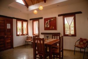 a dining room with a table and chairs and windows at Rinconcito en Tilcara in Tilcara