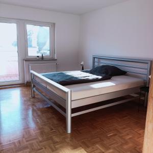una camera con un letto in una stanza con due finestre di City-Quartier a Bad Mergentheim