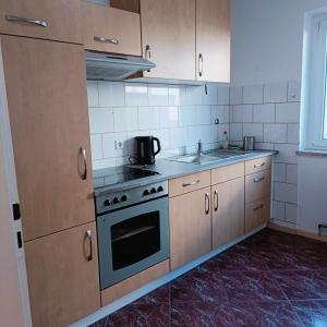 a kitchen with wooden cabinets and a stove top oven at City-Quartier in Bad Mergentheim +14 photos
