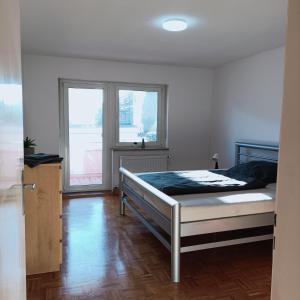 una camera da letto con un letto e due finestre di City-Quartier a Bad Mergentheim