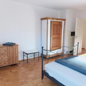 una camera con un letto, un comò e una porta di City-Quartier a Bad Mergentheim