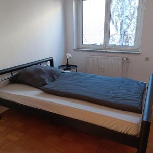 un letto con una coperta blu e una finestra di City-Quartier a Bad Mergentheim