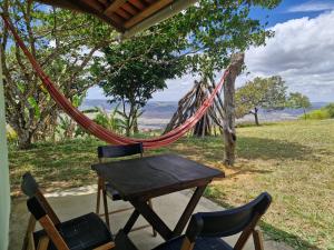 a table and two chairs and a hammock on a porch at Solar de Bonito - Casa Ingá in Bonito