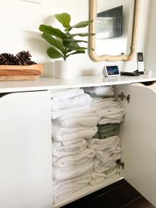 een plank vol handdoeken en een plant bij Lodgings by Lisa in Cooper City