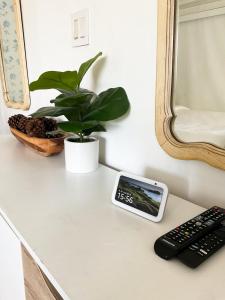 een afstandsbediening op een aanrecht met een klok en een plant bij Lodgings by Lisa in Cooper City