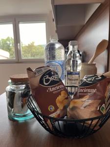 ein Korb mit Lebensmitteln auf einer Theke mit Wasserflaschen in der Unterkunft Appartement Le nid sur l'Ain in Champagnole