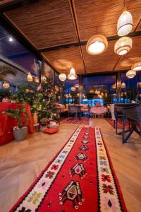 - un salon avec un arbre de Noël et un tapis rouge dans l'établissement Villa Green Garden, à Saranda