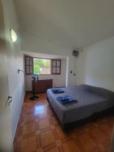 a bedroom with a bed and a desk and a window at Alojamiento Esparta in Villa Carlos Paz +2 photos