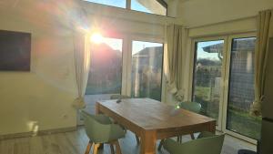 een eetkamer met een houten tafel en stoelen bij Haus Lüchtje Jade in Sehestedt