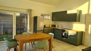 een keuken met een tafel, stoelen en een koelkast bij Haus Lüchtje Jade in Sehestedt