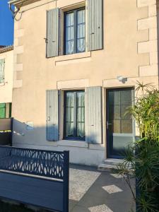 ein Gebäude mit blauen Türen und einem Zaun davor in der Unterkunft Arçais in Arçais