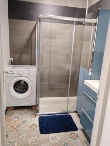 Waschmaschine und Trockner in einem kleinen Bad in der Unterkunft Arçais in Arçais