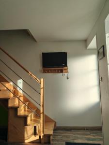 ein Wohnzimmer mit einer Treppe und einem TV an der Wand in der Unterkunft Arçais in Arçais