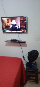 a room with a tv and a chair and a bed at Apartamento Próximo a Arena Pantanal in Cuiabá