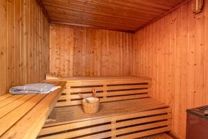 a wooden sauna with a bench in the middle at NEU! HeideVilla - Private Pool, Sauna & Mini Golf in Asendorf