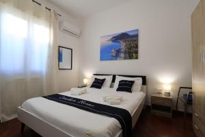 een slaapkamer met een groot wit bed met twee kussens bij Casa vacanze Ciachea Home - con BBQ , Parcheggio gratuito , A 10 min Da Palermo & Aeroporto in Carini