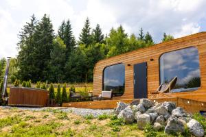 a wooden house with windows and some rocks at Woodydrem in Hruštín +7 photos
