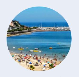 een groep mensen op een strand met de oceaan bij Vinoteca cerro in Piriápolis
