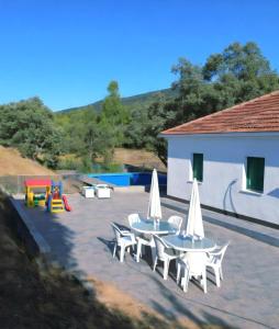 eine Terrasse mit Tischen und Stühlen und einem Pool in der Unterkunft Casa cruce de los molinos in La Aldehuela