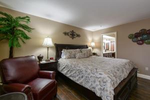 une chambre avec un lit et une chaise dans l'établissement Comfortable updated Condo with No steps, à Branson 34 autres photos