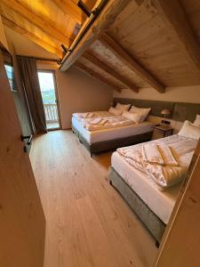 une chambre avec deux lits et une fenêtre dans l'établissement GOLDMARIE - Apartments, à Aschau