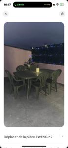 un tavolo verde con sedie di fronte a una finestra di La maison du bonheur a Montluçon