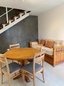 a dining room with a table and chairs and a couch at Aires del Rio Apart in Villa de Soto