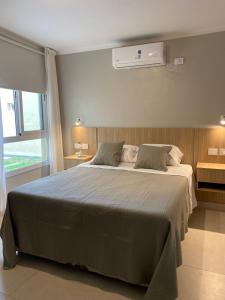 a bedroom with a large bed and a air conditioner at Aires del Rio Apart in Villa de Soto +34 photos