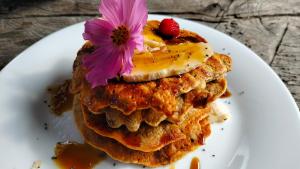 a plate with a stack of pancakes with a flower on top at Jacamaki- Eco-lodge & Reserva Natural in Villa de Leyva