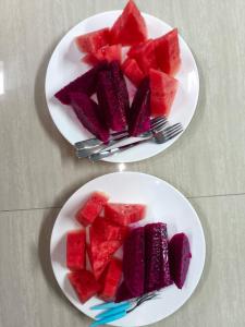 Twee schalen met rode en paarse watermeloen op een tafel. bij Toba-A-Scape in Ambarita