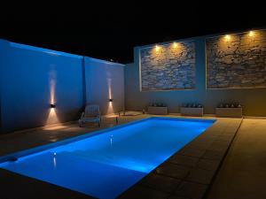 a swimming pool with blue lighting in a room at Aires del Rio Apart in Villa de Soto