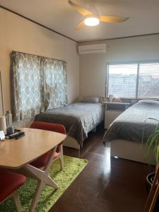 a room with two beds and a table and a dining room at base-k49 in Tenri