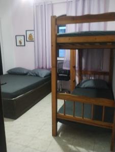 une chambre avec deux lits superposés et un bureau dans l'établissement Kitnet Cabo Frio 10, à Cabo Frio