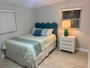 a bedroom with a bed and a nightstand and a window at Tropical Pool Haven Minutes to Downtown & beaches in Naples +19 photos