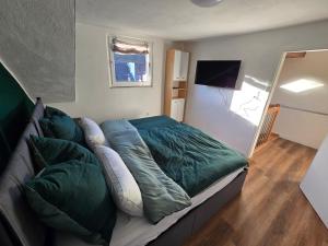 ein Bett mit Kissen auf einer Couch in einem Zimmer in der Unterkunft GreenHell Stays in Adenau