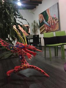 a red dragon statue sitting on the floor next to a plant at La Casa deVid in Parras de la Fuente