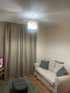 een woonkamer met een witte bank voor een raam bij Central Clonakilty House in Clonakilty