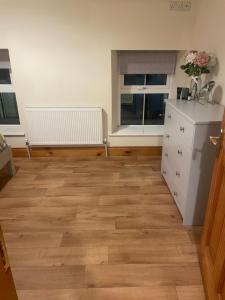 een kamer met een wit dressoir en een raam bij Central Clonakilty House in Clonakilty