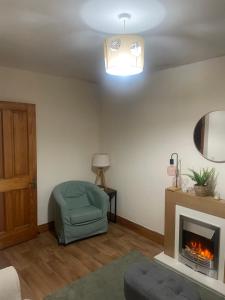 een woonkamer met een stoel en een open haard bij Central Clonakilty House in Clonakilty
