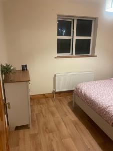 een slaapkamer met een bed en een raam bij Central Clonakilty House in Clonakilty +4 foto's