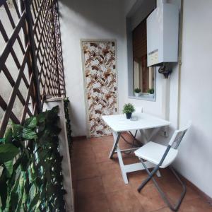 a white table and chair in a room with a plant at Maralbé Guest House in Messina