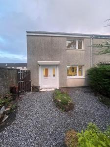 a house with a white door and a fence at Caledonian Lock House in Caol