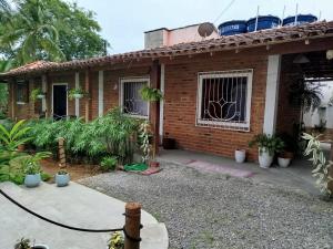 a brick house with a hose in front of it at Casa Beija Flor in Itacaré