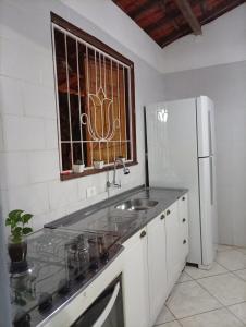 a kitchen with a sink and a refrigerator at Casa Beija Flor in Itacaré