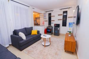 a living room with a blue couch and a table at Modern 1BR Apartment in Membley & near Ruiru Bypass, Kenyatta University & AMREF, Fast WiFi & Parking-Ruiru Membley in Ruiru