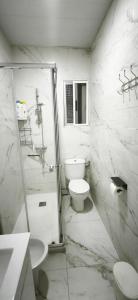 a white bathroom with a toilet and a shower at Playa de Sant Adrià de Besòs in Sant Adria de Besos